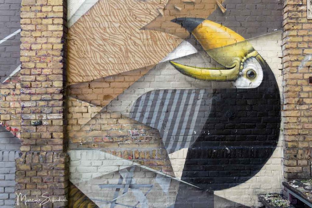 Urban Art am RAW-Gelände - Mural von einem exotischen Vogel am Backsteingebäude